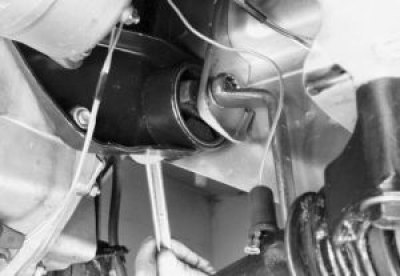 Отверните гайку и выньте болт левой опоры