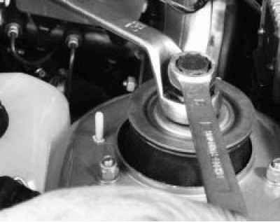 Ослабьте гайку верхнего крепления