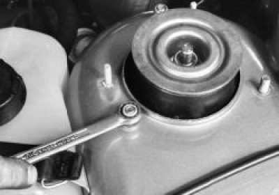 Отверните три гайки верхнего крепления